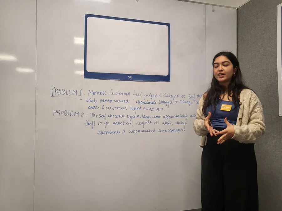 Navyaa presenting a design concept at a whiteboard.