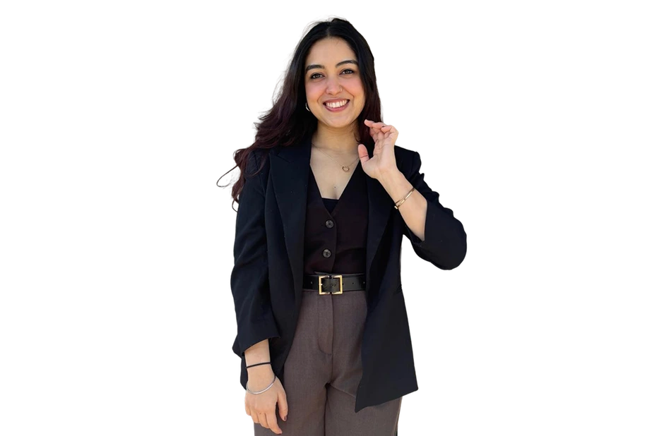 Navyaa smiling and waving, in a black blazer.