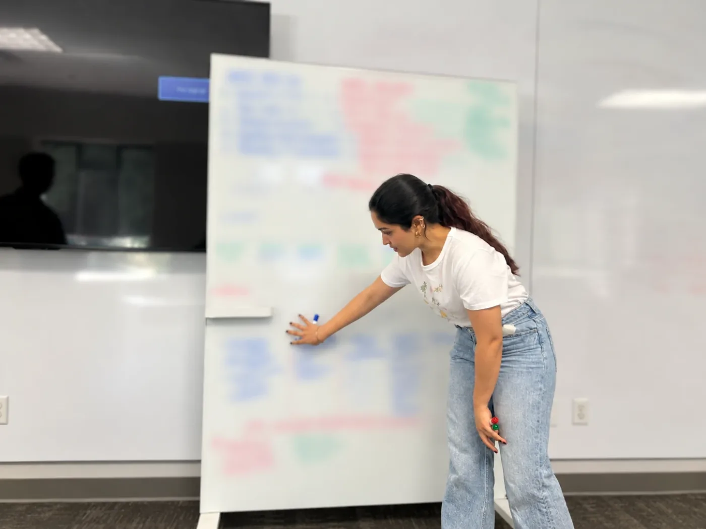 Navyaa walking a team through a framework at a whiteboard.